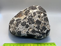 a rock made of black angular chunks of basalt surrounded by a white bubbly lava matrix.